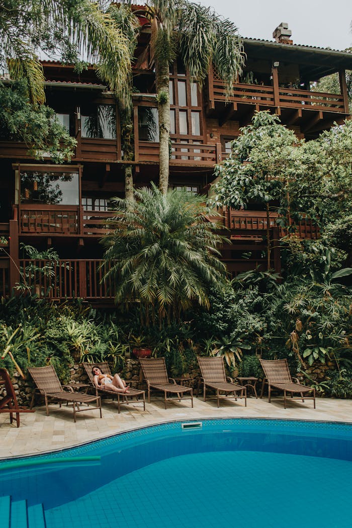 Relaxing poolside at a luxury resort with lush tropical surroundings in Bombinhas, Brazil.